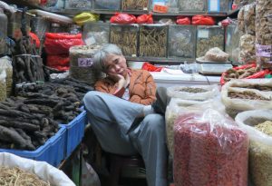 Chinese medicine vendor catching some zzz